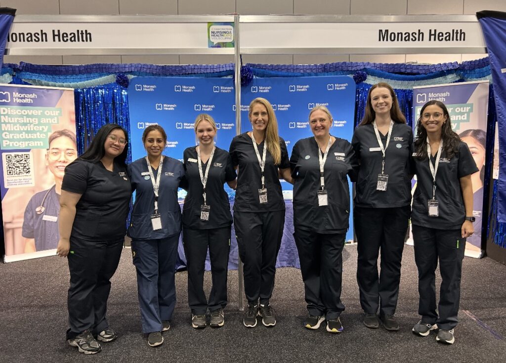 The Graduate Program team stands in front of the Monash Health stand at the careers expo.