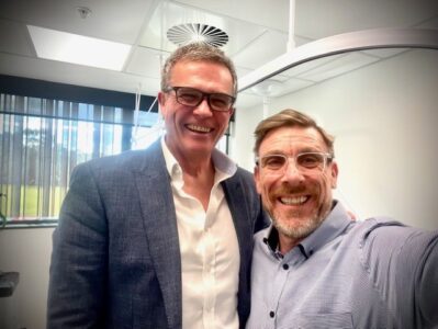 Professor Jayme Bennetts, surgeon and Director of Cardiothoracic Surgery at the Victorian Heart Hospital and Alex smile at the camera, sitting in a hospital room.